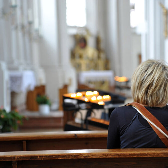 Eine Frau sitzt in der Kirche